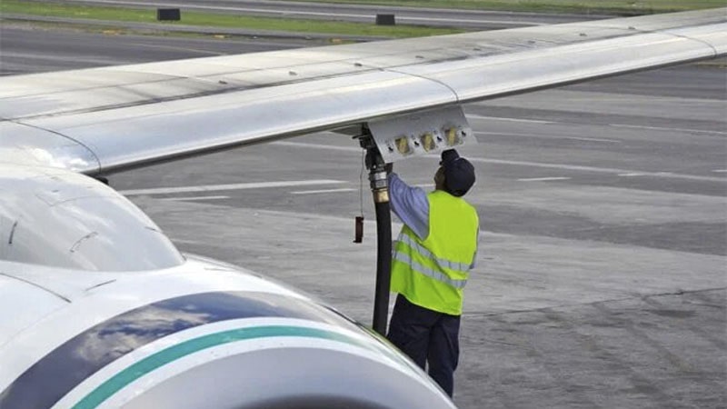 Operario echando combustible a un avión