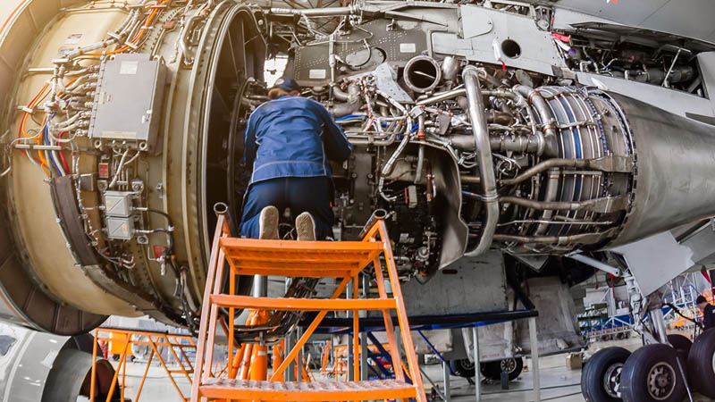 técnico realizando mantenimiento aeronáutico motor avión